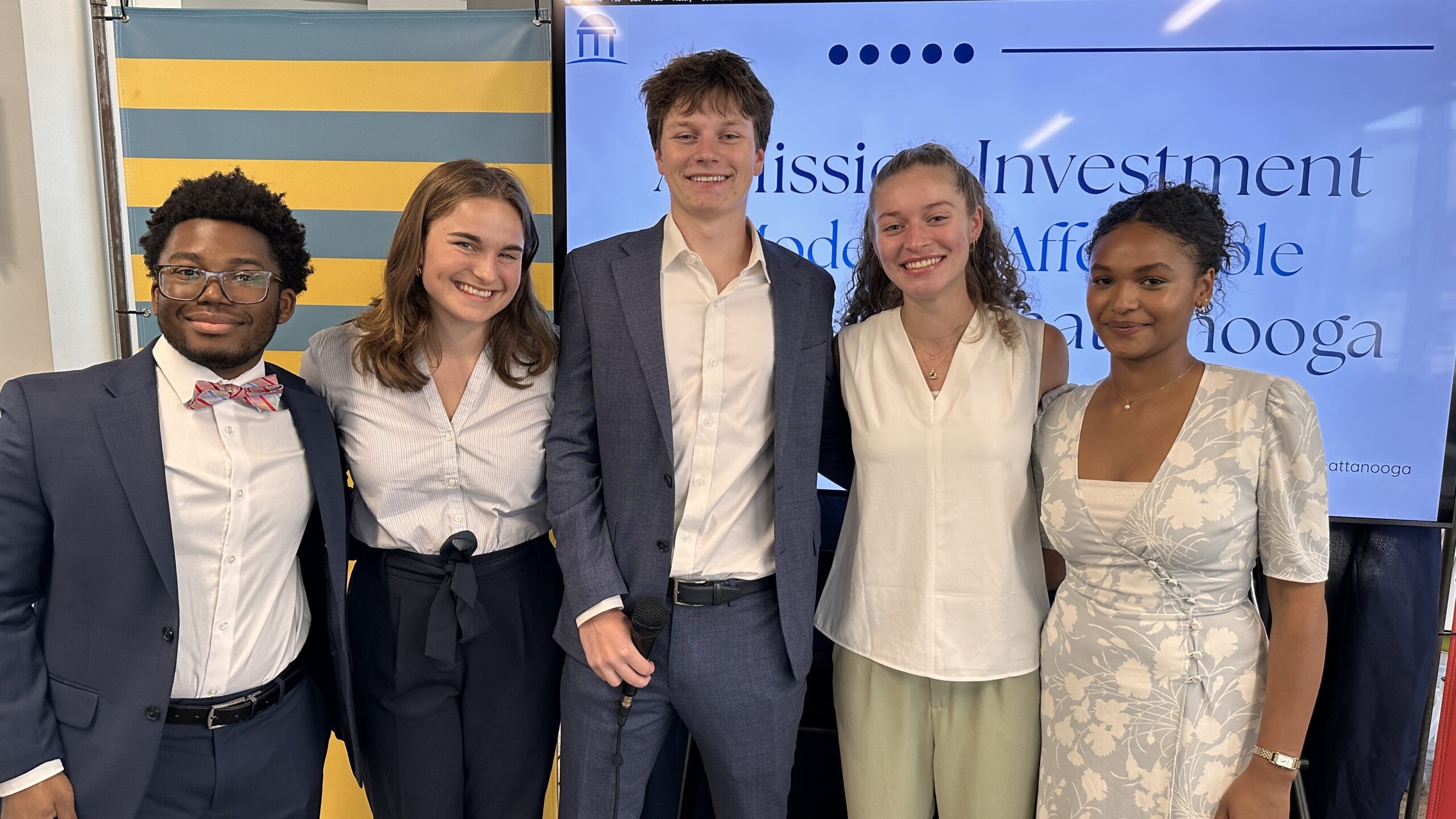 Five Morehead-Cain scholars from UNC standing in front of a presentation